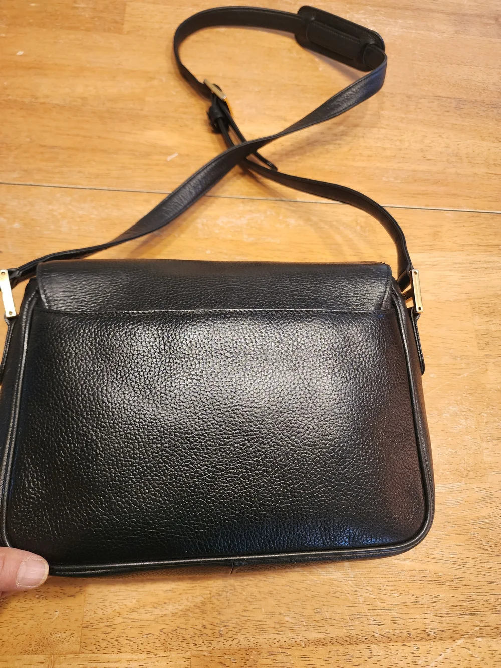 vintage MCM black pebbled leather studded crossbody bag featuring a front plaque